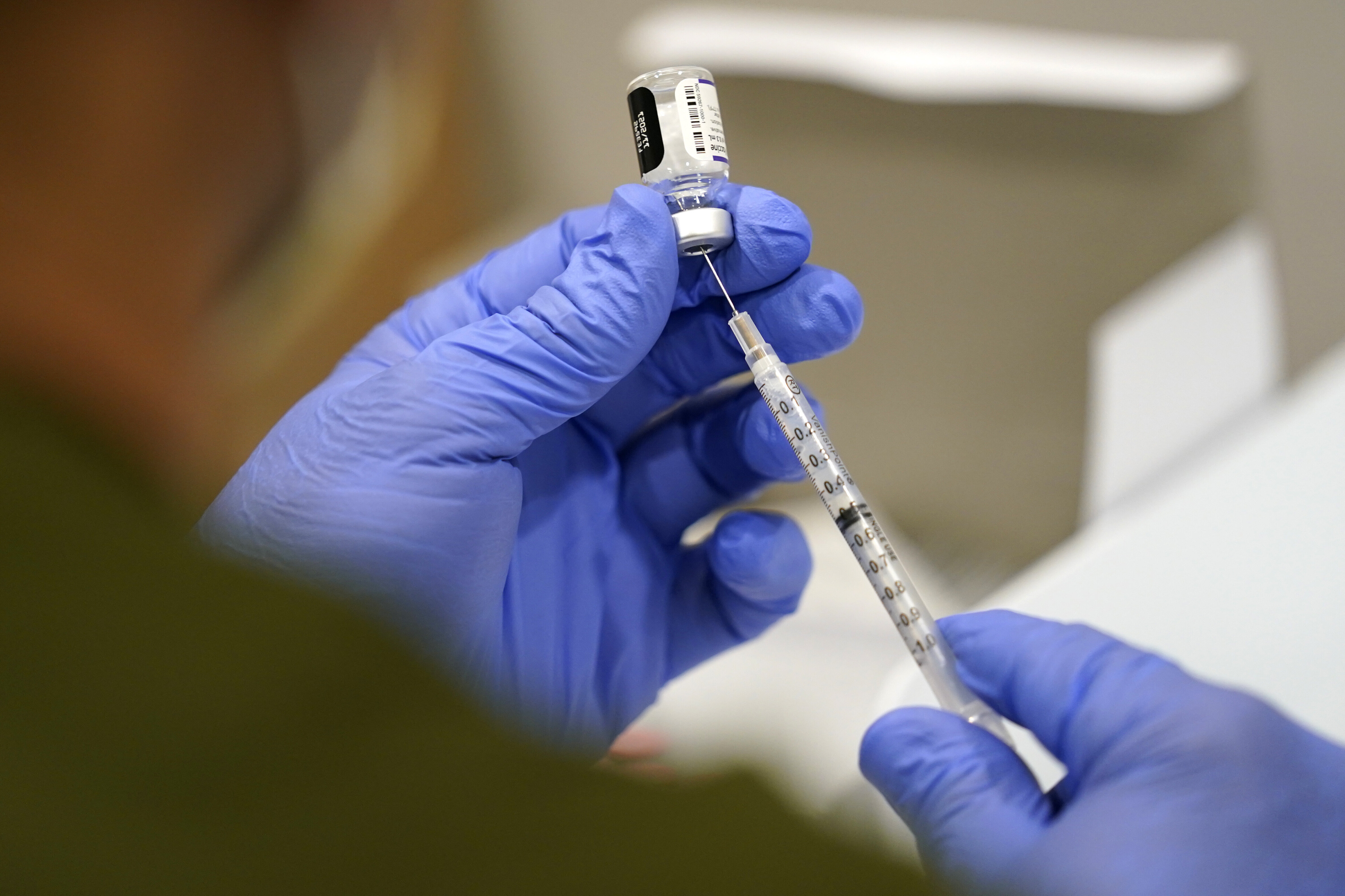 A healthcare worker fills a syringe with the Pfizer COVID-19 vaccine at Jackson Memorial Hospital in Miami. The man studied in Germany said he received the vaccination 217 times, though only 134 of those instances were proven by local officials.