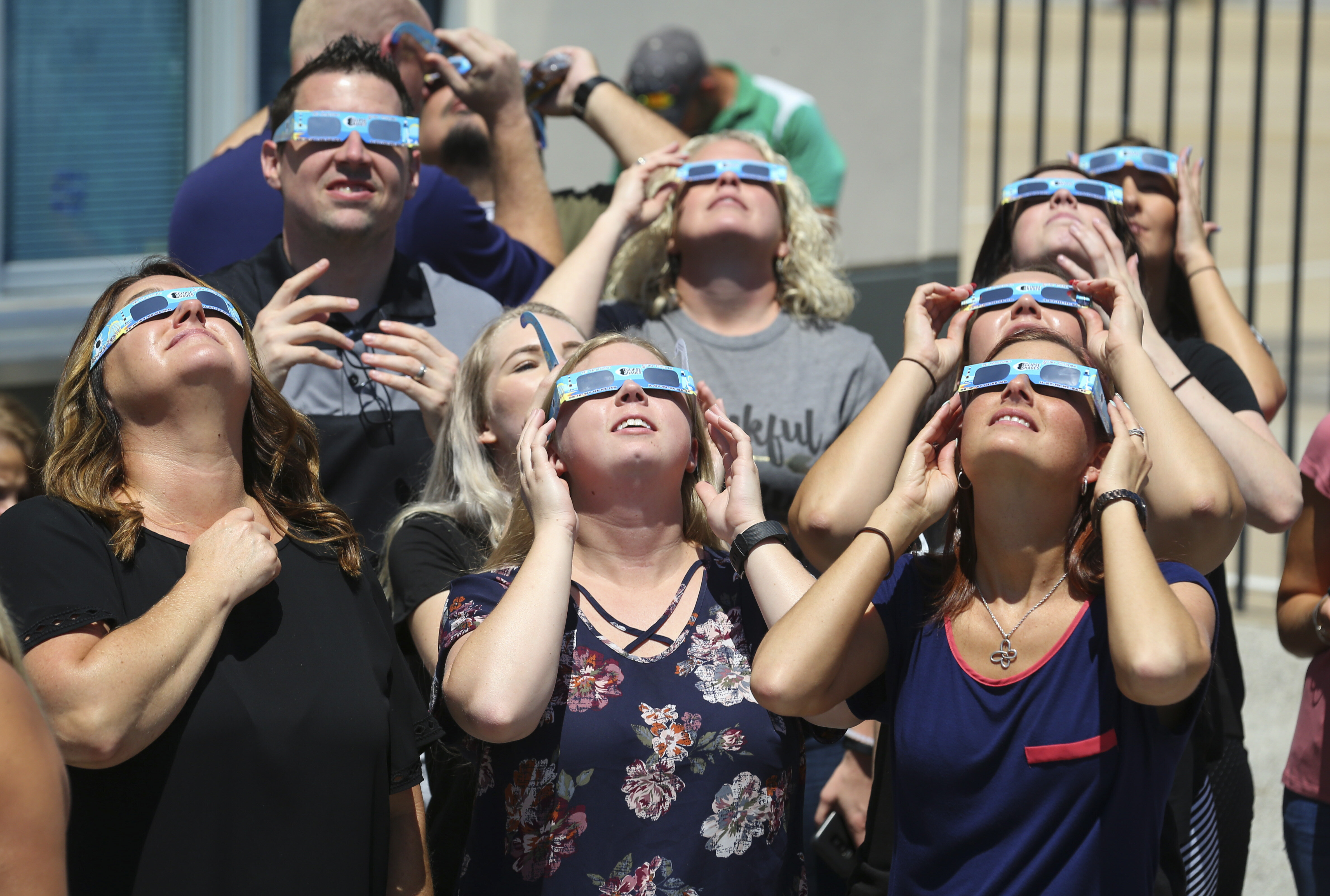 People watch the solar eclipse in Fort Worth, Texas, in 2017. Eclipse viewers are advised to wear specialized eyewear while looking at the sun to prevent eye damage. Normal sunglasses are not enough. 