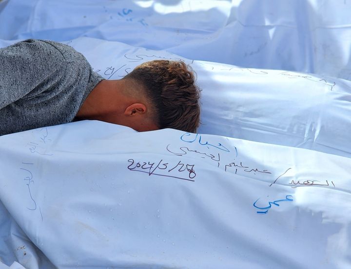 A Palestinian boy cries next to the bodies of those killed in an Israeli attack Monday west of Rafah, Gaza. At least 21 people were killed as Israeli forces shelled a tent camp in Al-Mawasi, the third such attack on areas designated by Israel as "safe zones" in the last 48 hours, the Rafah Emergency Committee said.
