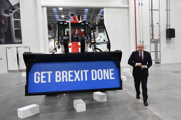 Then-U.K. Prime Minister Boris Johnson walks away after driving a backhoe, with the phrase "Get Brexit Done" inside the digger bucket, through a fake wall emblazoned with the word "Gridlock" in Uttoxeter, England, while on the 2019 general election campaign trail.