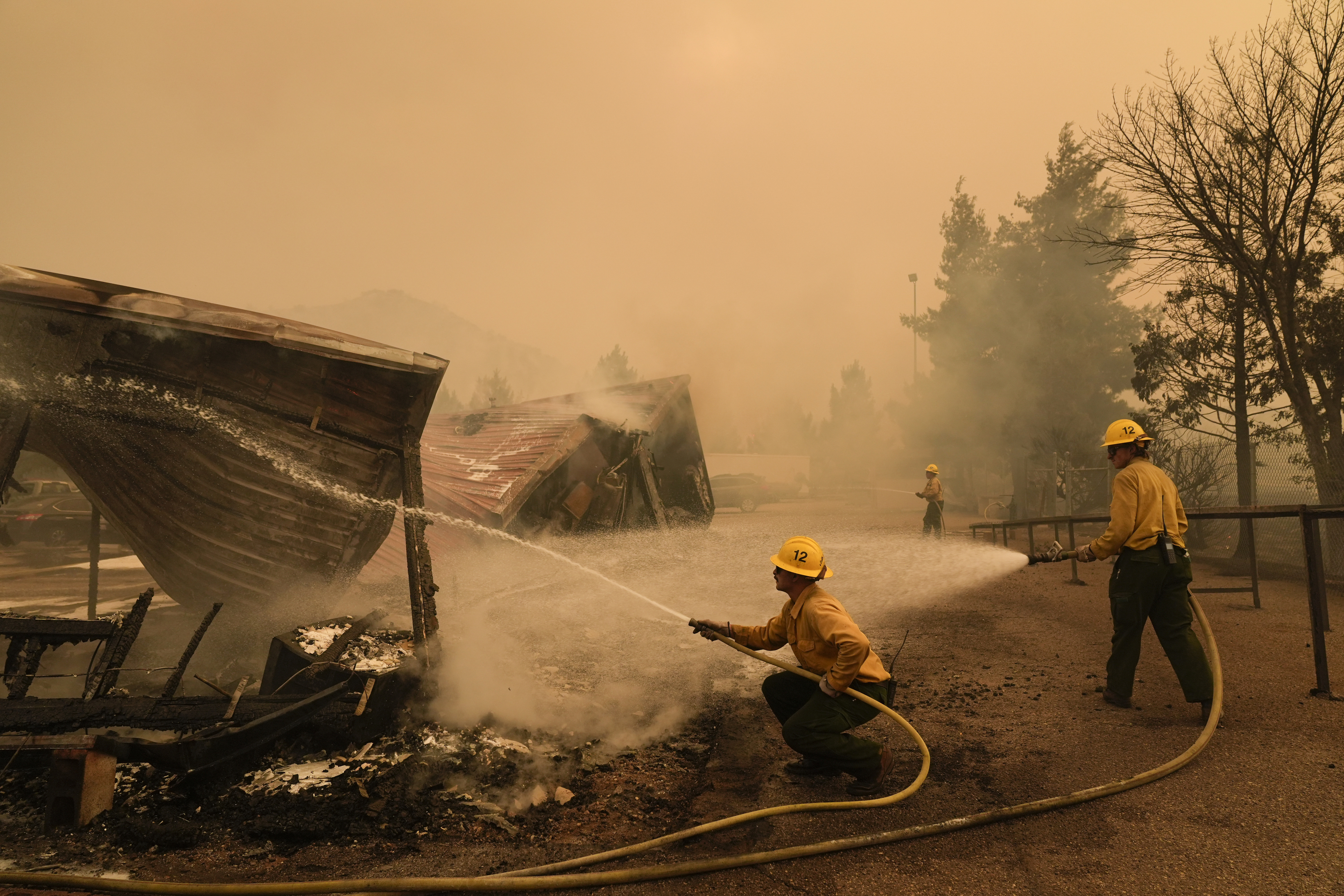 Firefighters hose down a structure at the Los Padres Forest Station while fighting the Post Fire on Saturday, June 15, 2024, in Lebec, Calif. (AP Photo/Marcio Jose Sanchez)