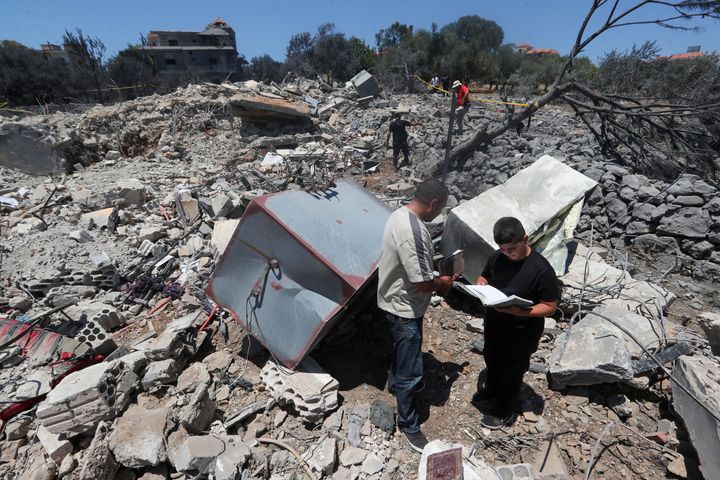 People inspect the rubble of a building on Friday, July 19, 2024, that was destroyed by an Israeli airstrike a night earlier in the southern village of Jmaijmeh, Lebanon.