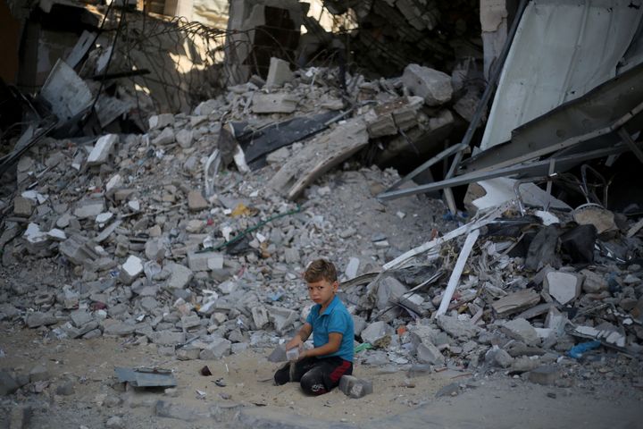 A Palestinian boy sits on the rubble of a building destroyed by an Israeli attack in the al-Bureij refugee camp in central Gaza on July 28, 2024.