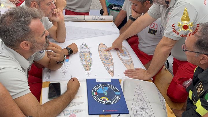 In this picture released by the Italian Firefighters Tuesday, Aug. 20, 2024, Scuba divers study a map of the sailing yacht Bayesian at the Porticello harbor. (Italian Firefighters via AP, HO)