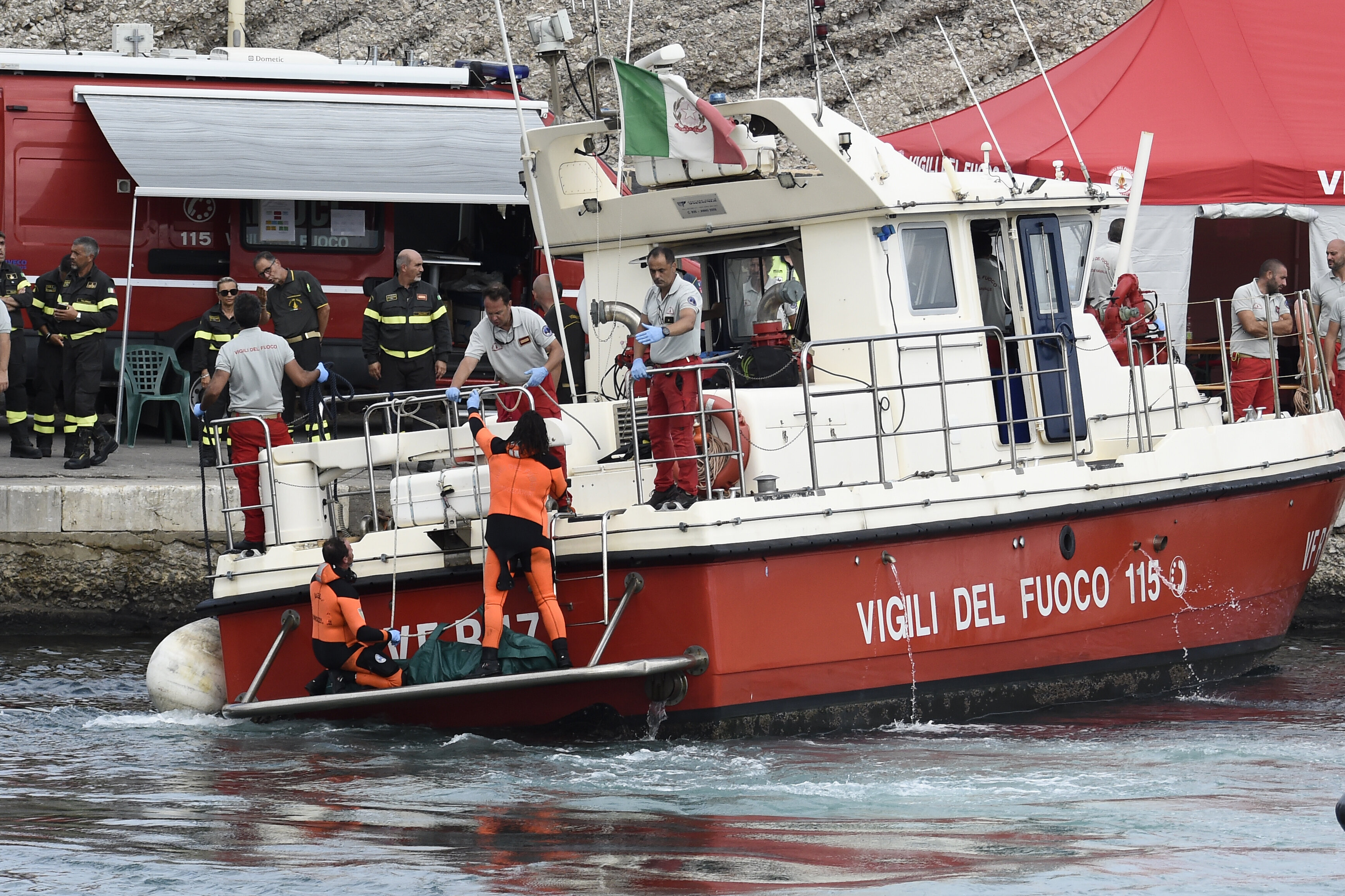 Italian Firefighters scuba divers bring ashore in a green bag the body of one of the victims of the UK flag vessel Bayesian, Wednesday, Aug. 21, 2024. (AP Photo/Salvatore Cavalli)