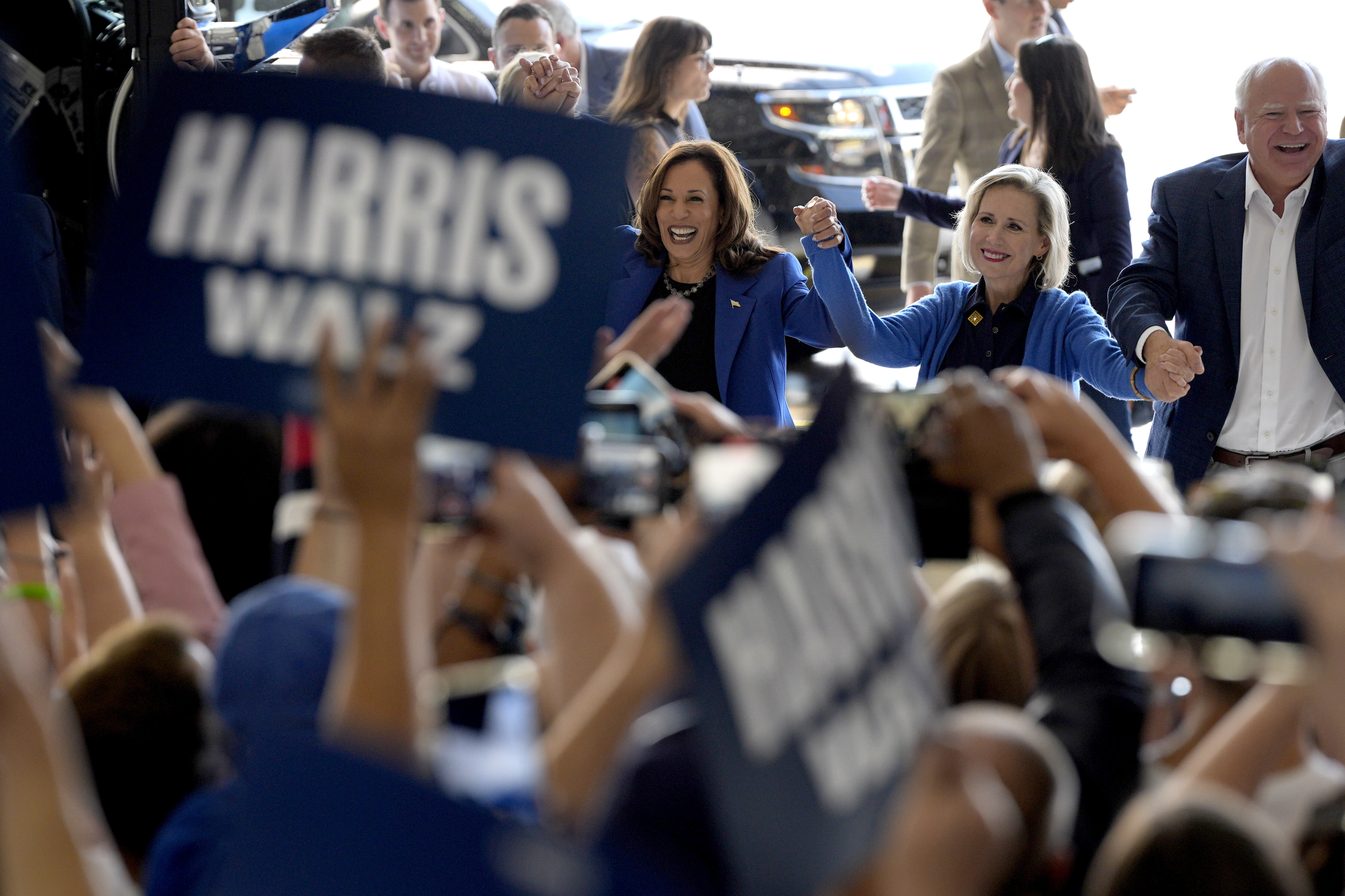 Democratic presidential nominee Vice President Kamala Harris, left, Democratic vice presidential nominee Minnesota Gov. Tim Walz, right, and his wife Gwen Walz arrive at Pittsburgh International Airport, Sunday, Aug. 18, 2024, in Pittsburgh, (AP Photo/Julia Nikhinson)