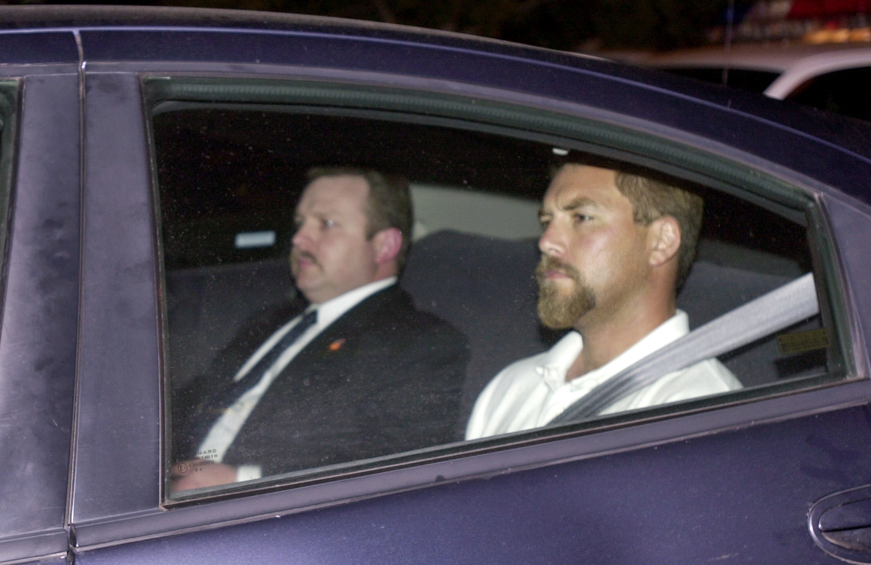 Scott Peterson (right) arrives at a county jail in Modesto, California, after being taken into custody in San Diego on April 19, 2003, in connection with the death of his wife, Laci Peterson, who was 8½ months pregnant when she went missing the previous Christmas Eve. With him in the back seat is Detective Craig Grogan.