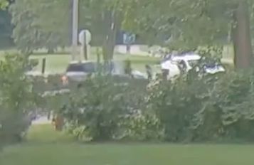 A bystander's truck is seen blocking a car after the driver tried to take off with a 7-year-old in Sterling Heights, Michigan, the police department said.