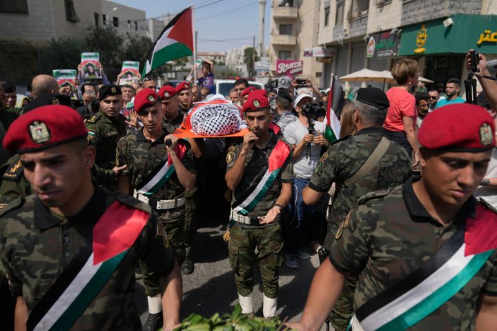 A Palestinian honor guard carries the body of Aysenur Ezgi Eygi, 26, who a witness says was fatally shot by Israeli soldiers while participating in an anti-settlement protest in the West Bank, during her funeral procession in the West Bank city of Nablus, Monday, Sept. 9, 2024. (AP Photo/Nasser Nasser)