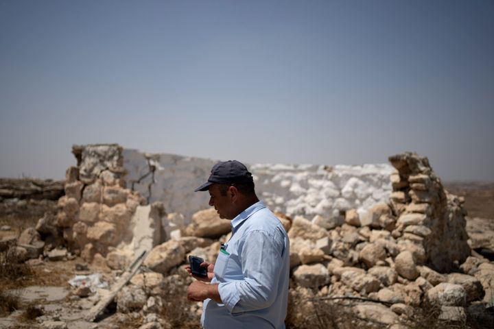 Fayez Suliman Tel, head of the village council for Khirbet Zanuta, stands next to a home that was destroyed when his community was driven out by Israeli settlers, Tuesday, Aug. 27, 2024. (AP Photo/Maya Alleruzzo)