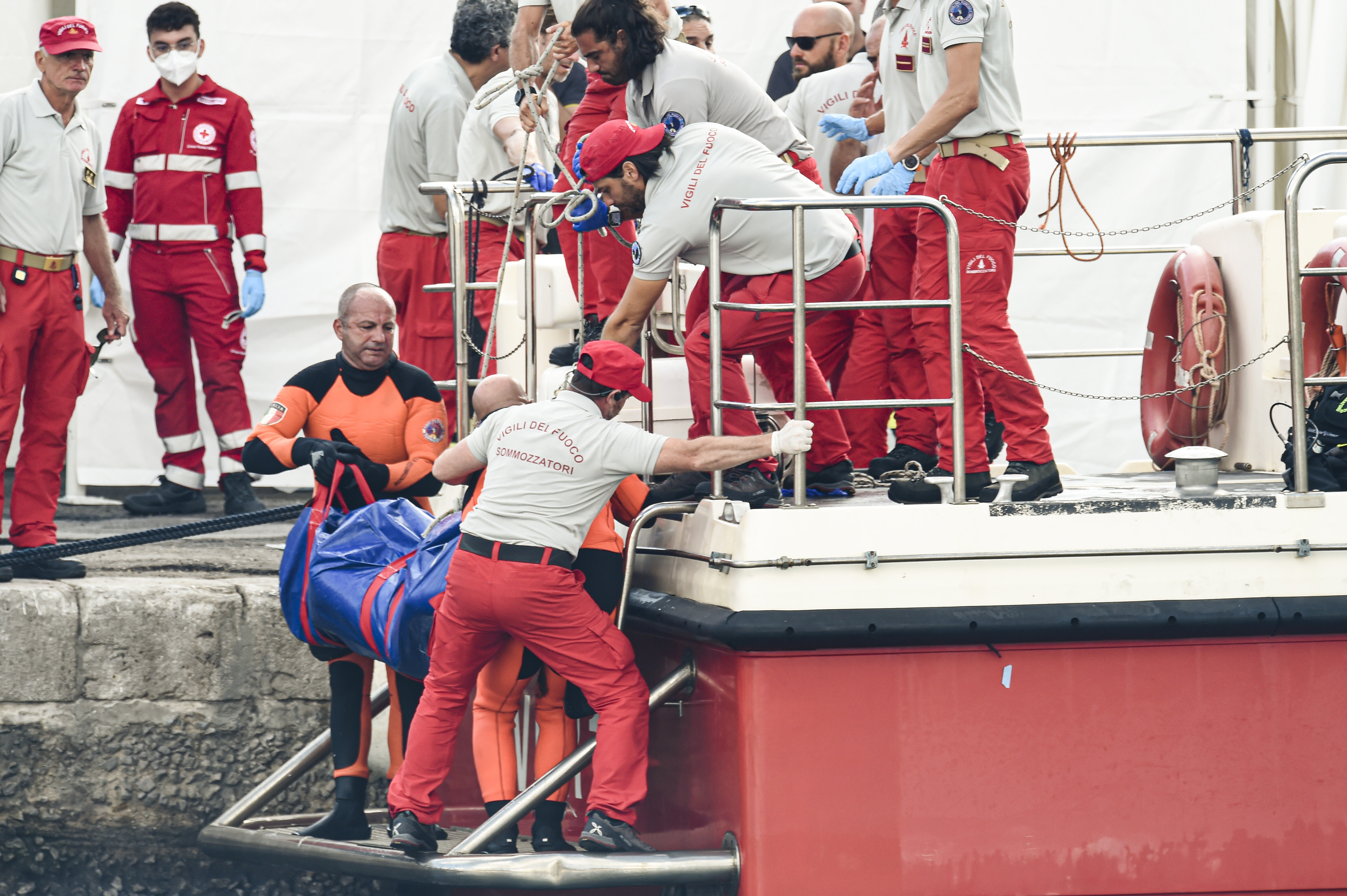 Italian firefighter divers bring ashore the body of one of the victims of a shipwreck in Porticello, Sicily, on Aug. 22.