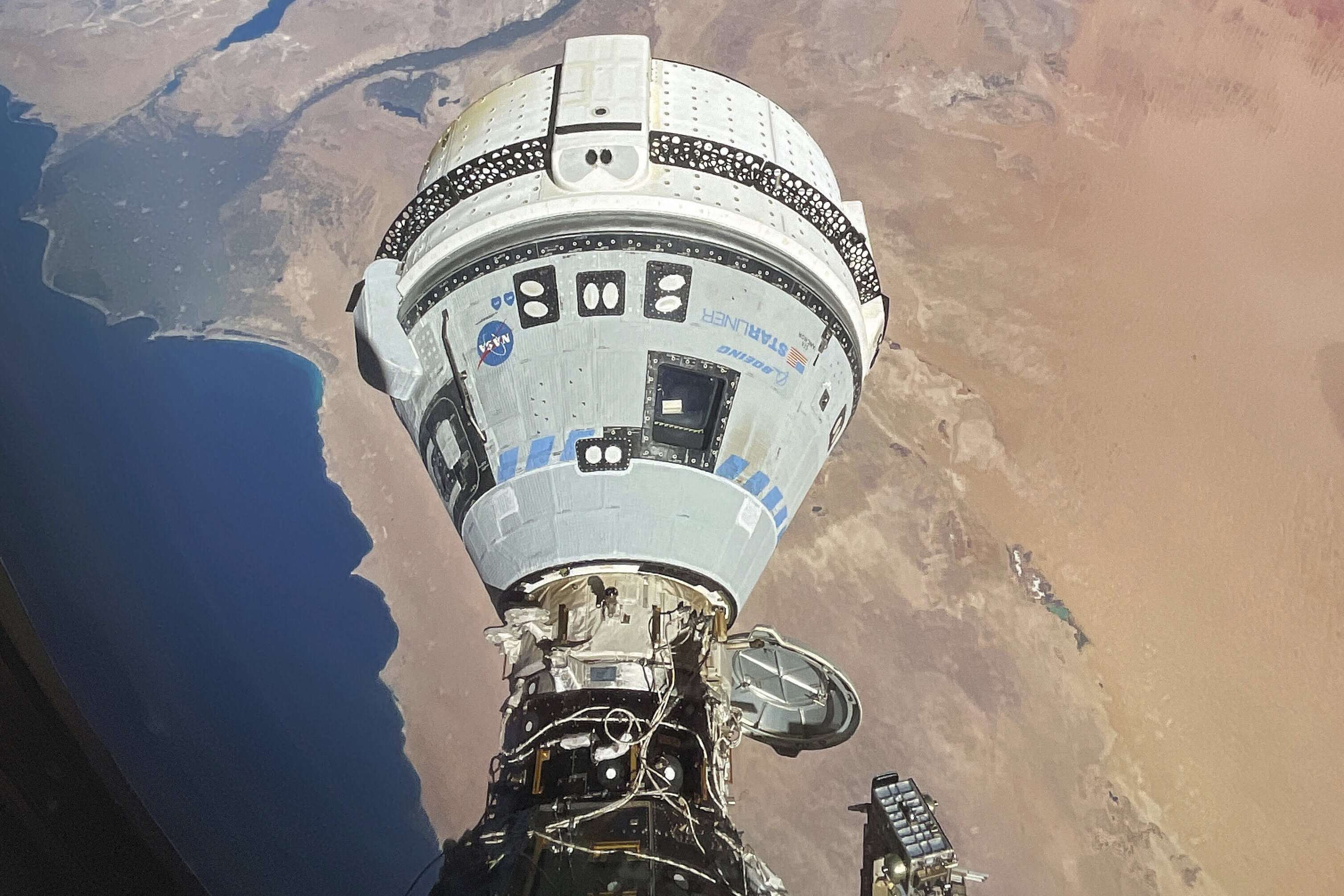 Boeing's Starliner spacecraft, seen docked with the International Space Station on June 13, is scheduled to return to Earth on Friday without passengers. 