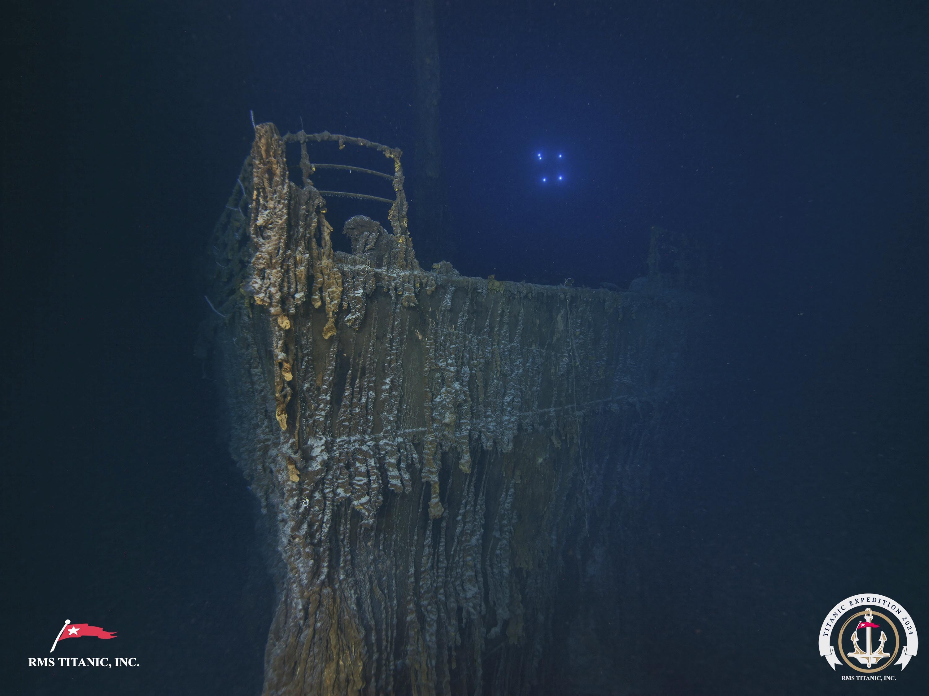 The bow of the Titanic is seen with a large section of the deck railing now missing.