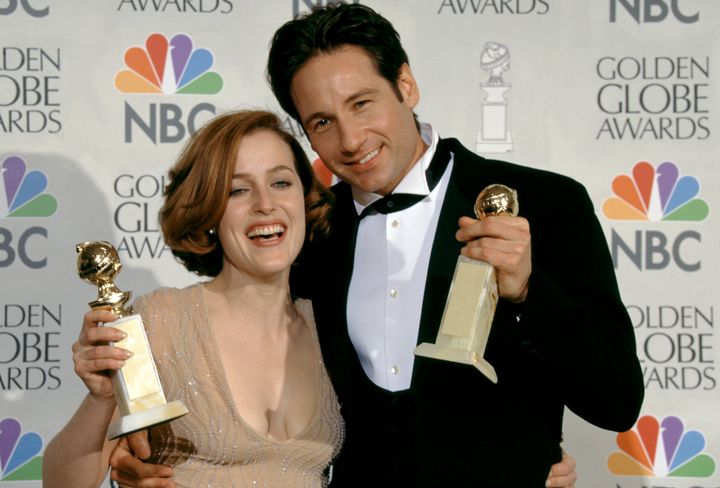 Anderson and Duchovny hold their Golden Globes in the press room during the 54th Annual Golden Globe Awards on Jan. 19, 1997.