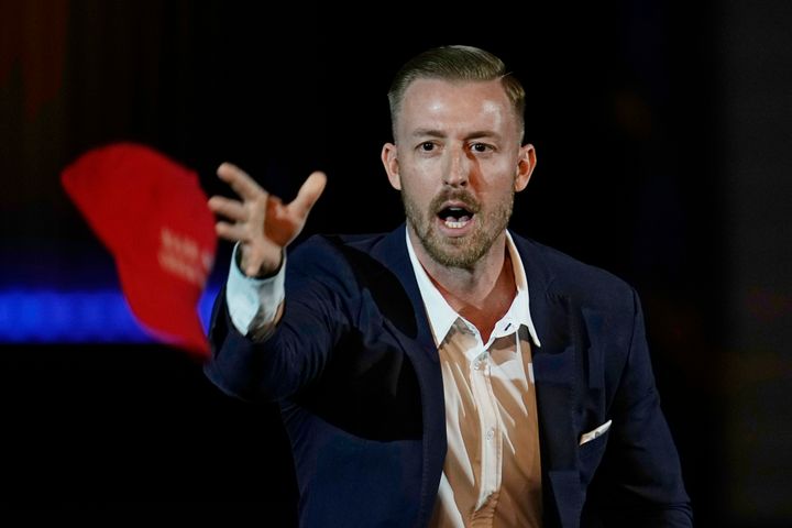 Ryan Walters, then-Republican candidate for Oklahoma state superintendent, tosses out "Make America Great Again" ball caps at a 2022 rally in Oklahoma City.