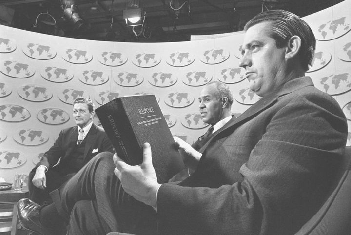 FILE - Sen. Fred R. Harris (D-Okla.), holds a copy of the report of the National Advisory Commission on Civil Disorders as he and two other members of the commission discuss the study on the television-radio program "Issues and Answers," in Washington, March 3, 1968. (AP Photo/Bob Daugherty, File)