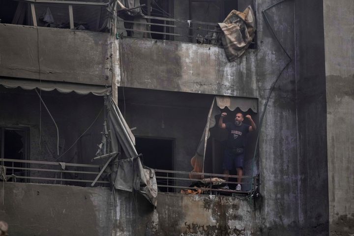 A man stands on the balcony of his damaged apartment at the site of an Israeli airstrike in Dahiyeh, Beirut, Lebanon, Friday, Nov. 1, 2024. (AP Photo/Hassan Ammar)