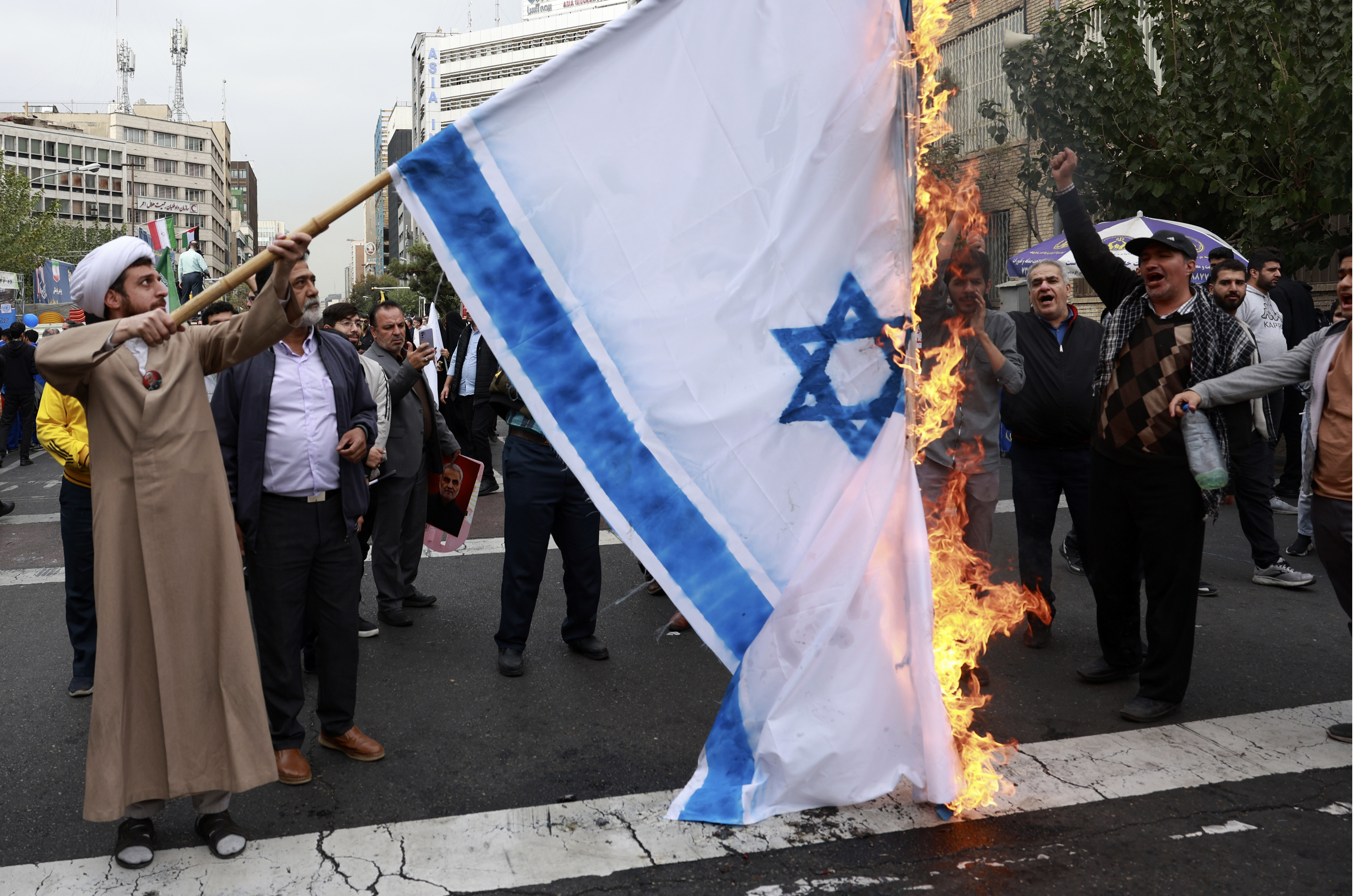 Iranian demonstrators burn a representation of the Israeli flag in an annual rally in front of the former U.S. Embassy in Tehran, Iran, Sunday, Nov. 3, 2024, marking the 45th anniversary of Iranian students' takeover of the embassy, starting a hostage crisis. (AP Photo/Vahid Salemi)