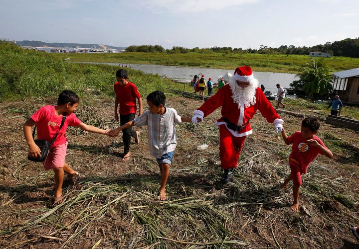 Santa Claus has braved the sticky heat of the Amazon rainforest this weekend, taking two boats to bring gifts to the children of a small village near the Brazilian city of Manaus.