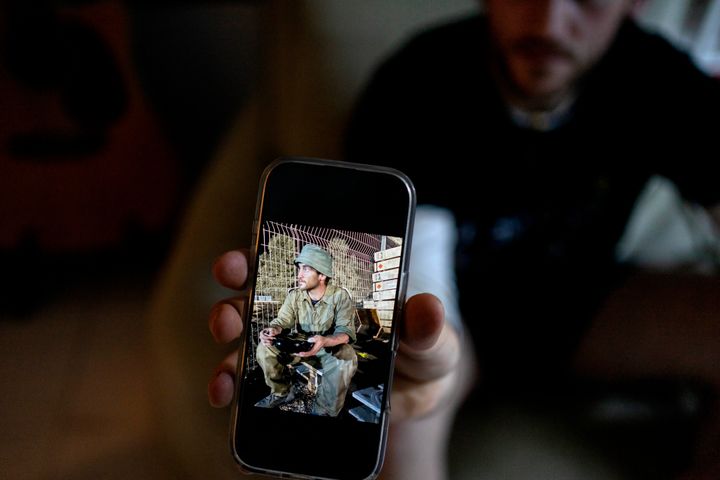 Yotam Vilk shows a photo of himself on the Israel-Gaza border during army reserve duty before he joined a growing number of Israeli soldiers speaking out against the 15-month war and refusing to continue fighting, at home in Tel Aviv, Israel, on Friday, Jan. 10, 2025.