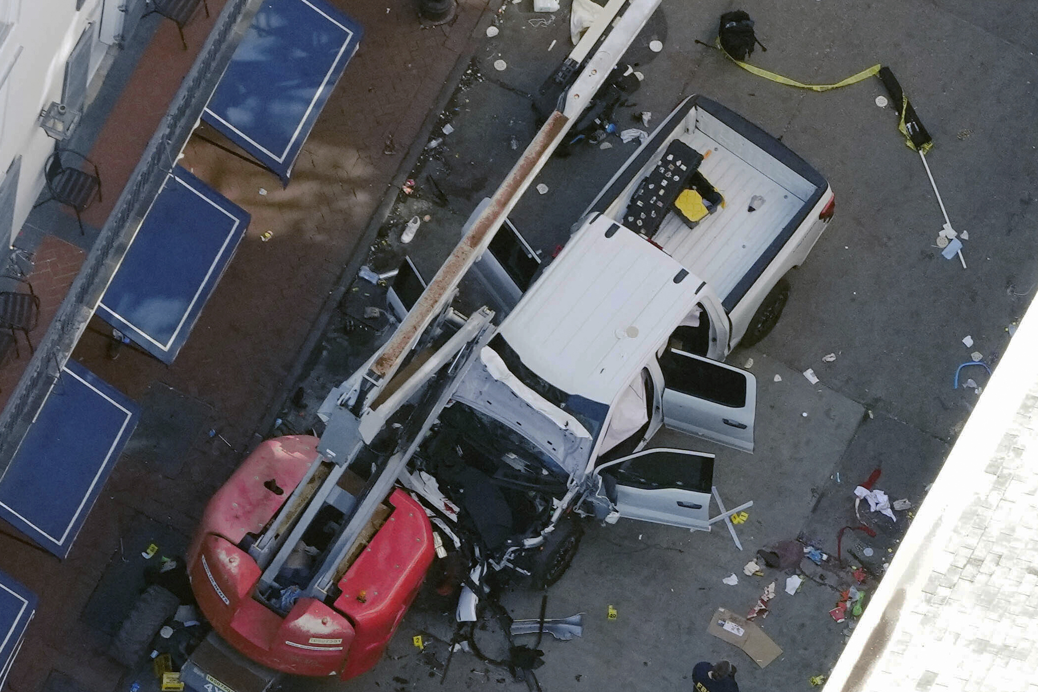 FILE - A black flag with white lettering lies on the ground rolled up behind a pickup truck that a man drove into a crowd on Bourbon Street in New Orleans, killing and injuring a number of people, early Wednesday morning, Jan. 1, 2025. (AP Photo/Gerald Herbert, File)