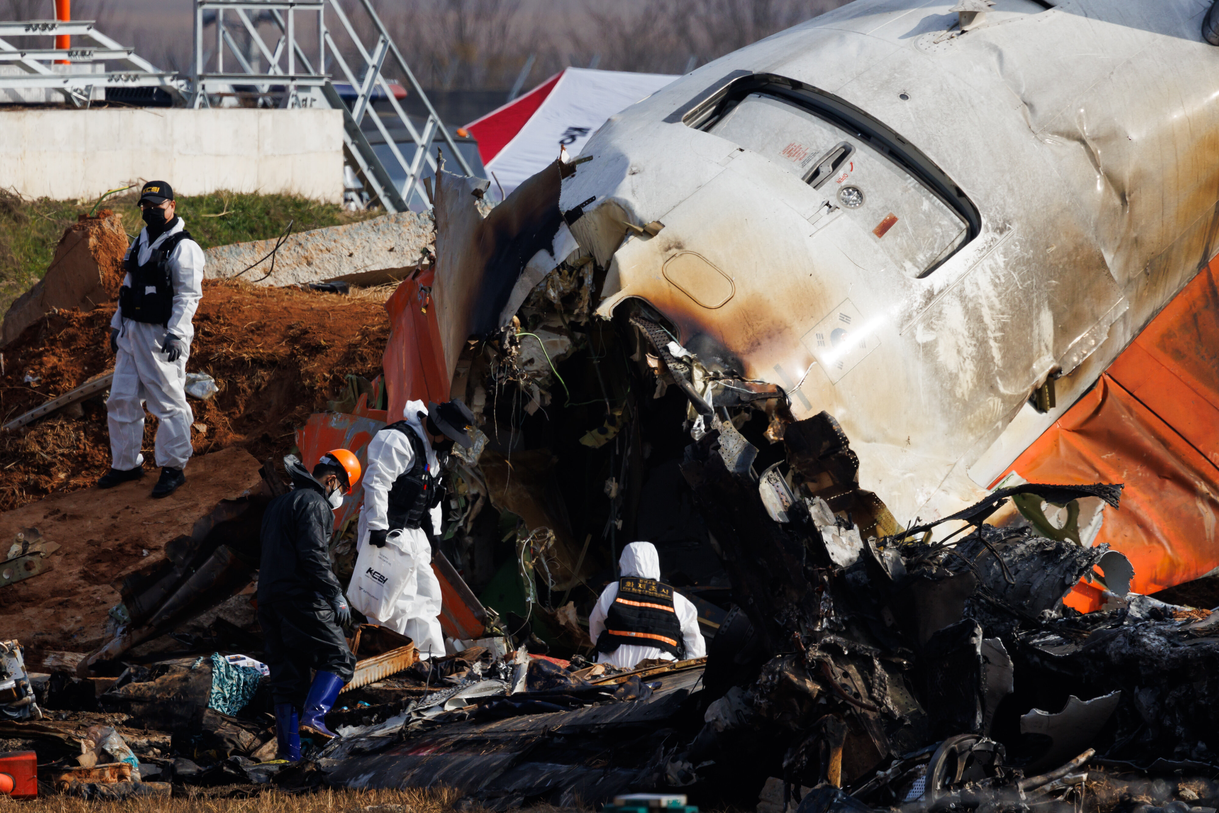 Forensic investigators inspect the wreckage of Jeju Air Co. Flight 2216 at Muan International Airport in South Korea on Monday.