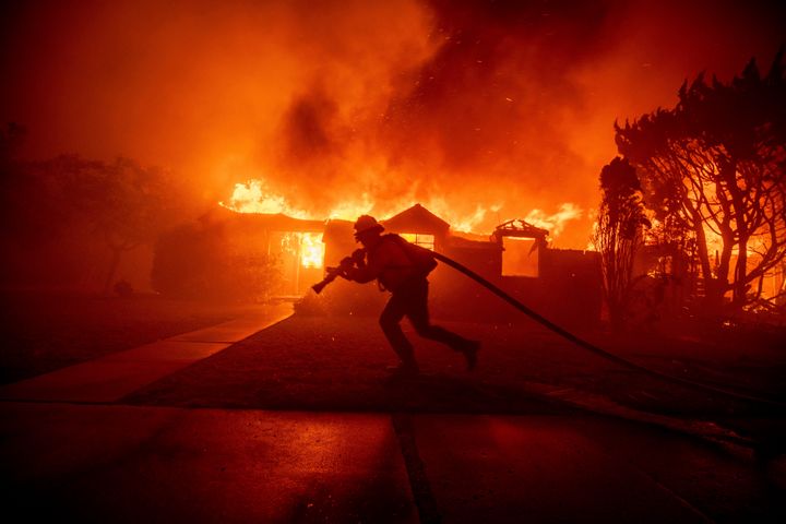 A firefighter battles the Palisades Fire as it burns a structure in the Pacific Palisades neighborhood of Los Angeles, on Jan. 7, 2025.