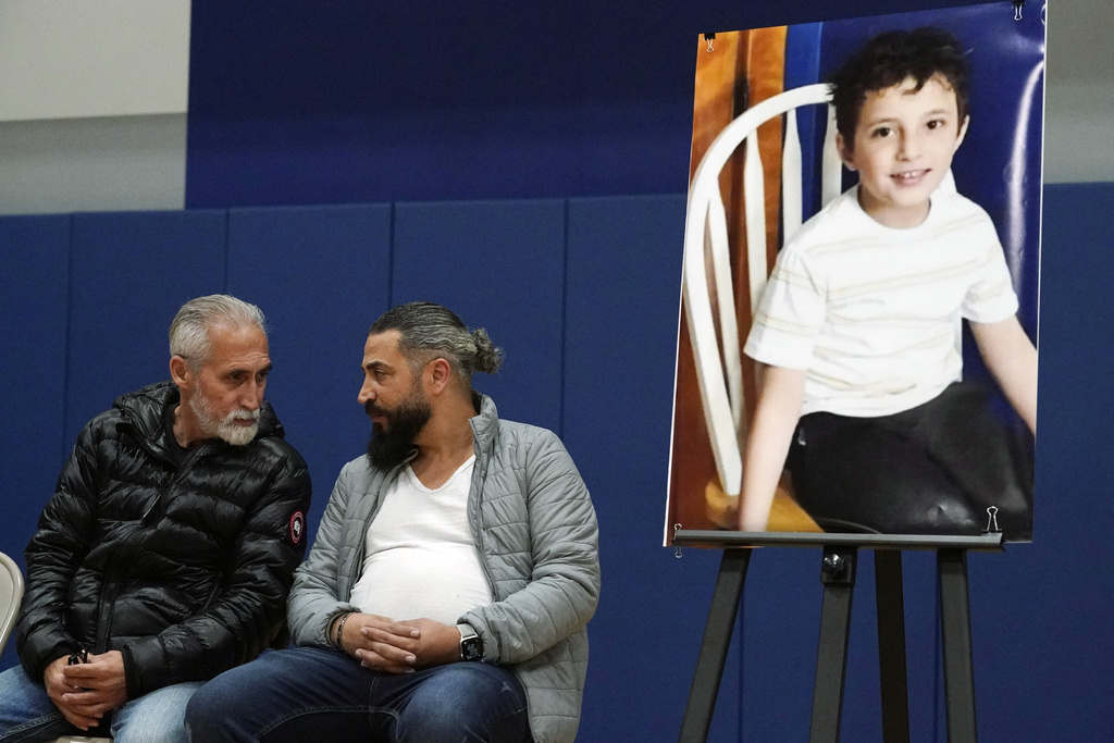 Wadee Alfayoumi's father, Oday Al Fayoume, seated right, and his uncle Mahmoud Yousef attend a vigil for Wadee at Prairie Activity and Recreation center in Plainfield, Ill., Oct. 17, 2023.