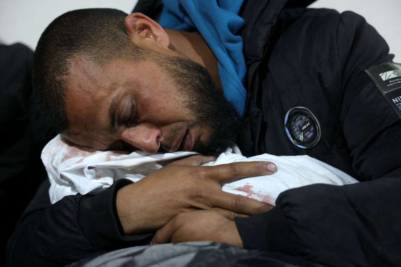 A Palestinian man hugs the body of a baby who was killed in Israel's overnight airstrikes at the Indonesian Hospital in Beit Lahia on March 20, 2025.