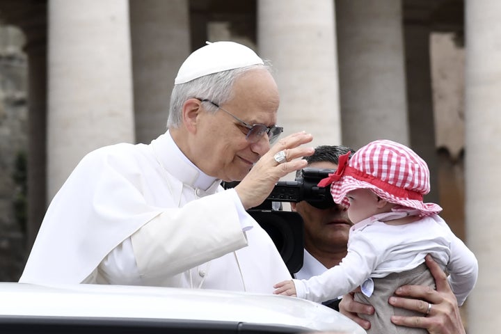 Pope Leo XIV greets a baby as he arrives at his first general audience in St. Peter's Square at the Vatican on May 21, 2025. The new pope spoke out specifically against the worsening humanitarian crisis in Gaza, calling on Israel to allow "dignified" aid into the territory and for an end to all hostilities, "whose heartbreaking price is paid by children, the elderly and the sick."