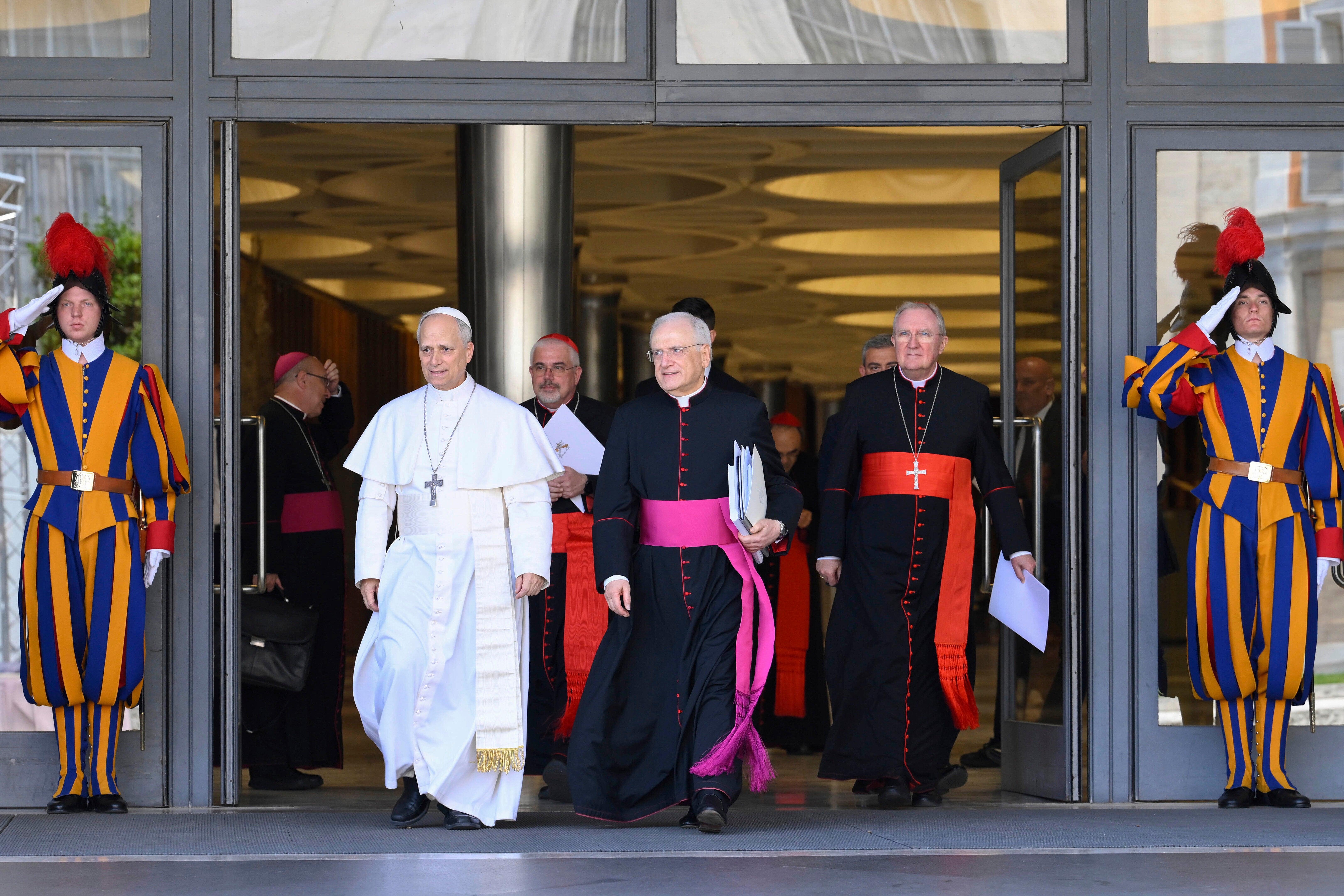 Pope Leo XIV, left, is flanked by Monsignor Leonardo Sapienza, second from left, after his meeting with the College of Cardinals in the New Synod Hall at the Vatican, Saturday, May 10, 2025. (Vatican Media via AP)
