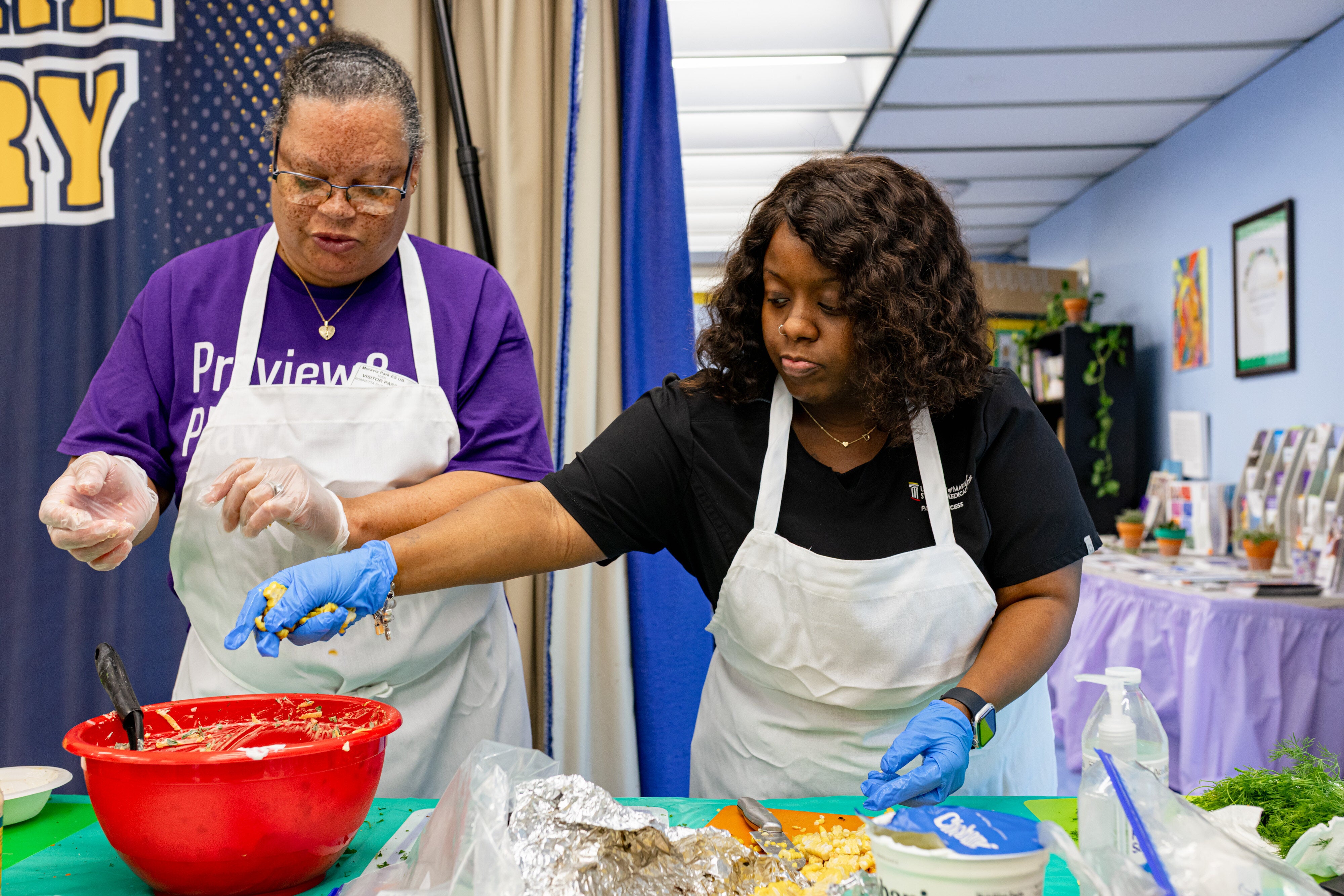 Ronnetta Suber, left, and Shanequa Witherspoon prepare pasta salad during a SNAP-Ed class on home cooking and gardening at Moravia Park Elementary School in Baltimore, Maryland, on June 4.