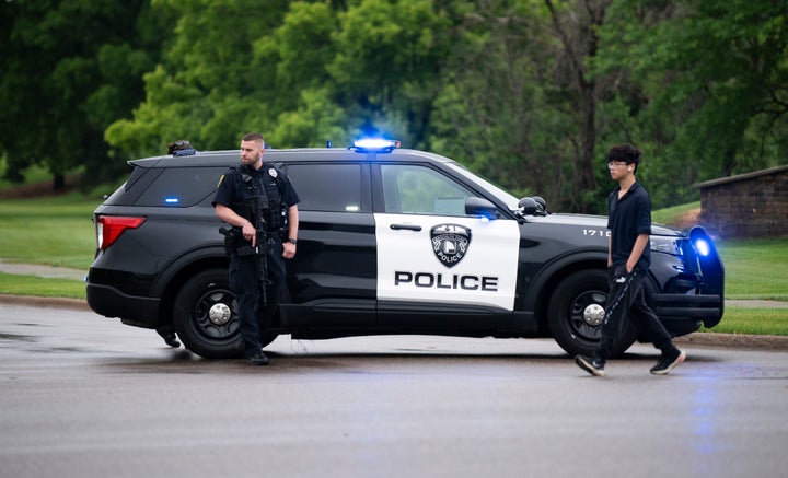 A Brooklyn Park police officer looks on as they guard the entrance to a neighborhood in Brooklyn Park, Minnesota, on Saturday.