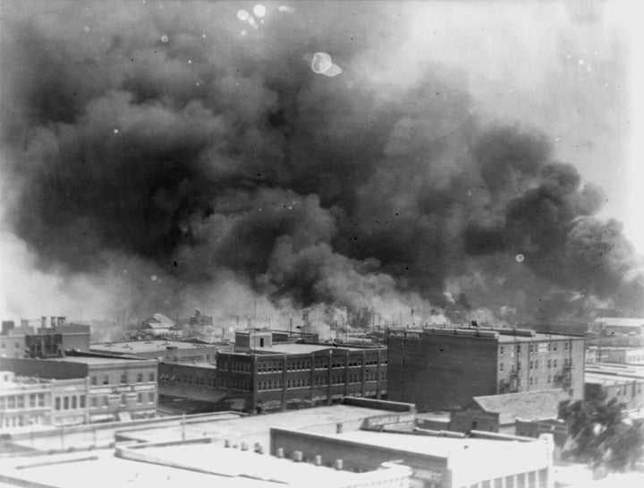 In this 1921 image provided by the Library of Congress, smoke billows over Tulsa, Oklahoma. For decades, when it was discussed at all, the killing of hundreds of people in a prosperous Black business district in 1921 was referred to as the Tulsa race riot. Under recent standards developed by teachers for approaching the topic, students are encouraged to consider the differences between labeling it a “massacre” instead of a “riot.”